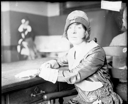 Florence Stokes looking toward the camera, sitting at a table in a room - Chicago Daily News, Inc.