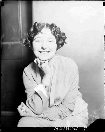 Olive Schick looking toward the camera, sitting in a room - Chicago Daily News, Inc.