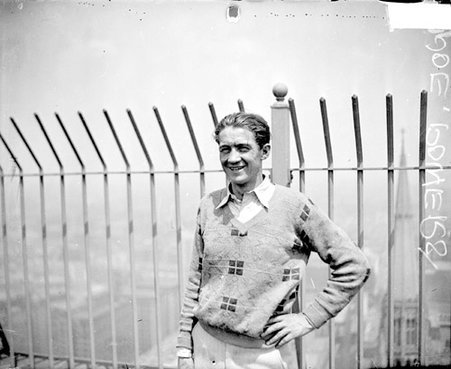 Joe Powers, flag pole sitter, standing on a rooftop - Chicago Daily News, Inc.