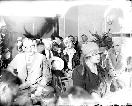 Mary Meyers, Mrs. Thomas Kehoe, men and other women sitting in a crowded room - Chicago Daily News, Inc.
