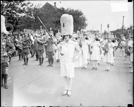 Lake County High School Band leader, Alice Hammond, and the band, standing on a residential street in Lake County, Indiana - Chicago Daily News, Inc.