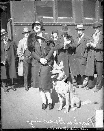 Actress Frances Heenan Browning (known as Peaches or The Girl Wonder) looking towards camera and smiling, standing with a German Shepherd dog - Chicago Daily News, Inc.