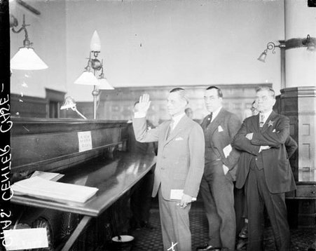 Charles Center raising his right hand, standing in front of a judge's bench in a courtroom - Chicago Daily News, Inc.