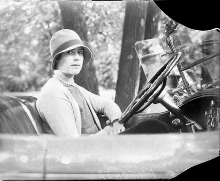 Alice Mitchell sitting in the driver seat of a convertible automobile, looking toward the camera - Chicago Daily News, Inc.