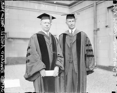 James Rowland Angell and Max Mason facing the camera, wearing scholarly robes standing in front of a building - Chicago Daily News, Inc.