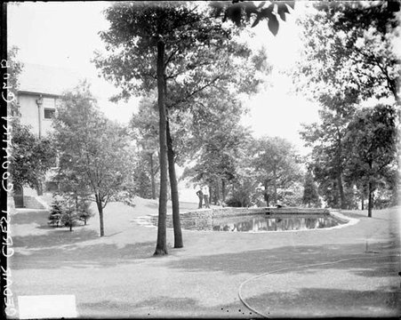 Two men standing near a small pond at the Cedar Crest Country Club in Quincy, Illinois - Chicago Daily News, Inc.