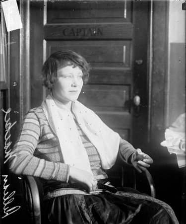 Lillian Mace looking to the right of the camera, sitting at a table in a room - Chicago Daily News, Inc.
