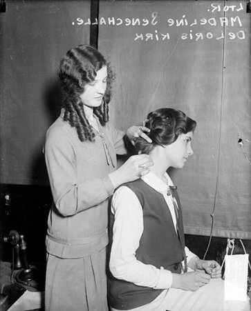 Madeline Senechalle standing in a room behind DeLoris Kirk who is sitting, styling Kirk's hair - Chicago Daily News, Inc.