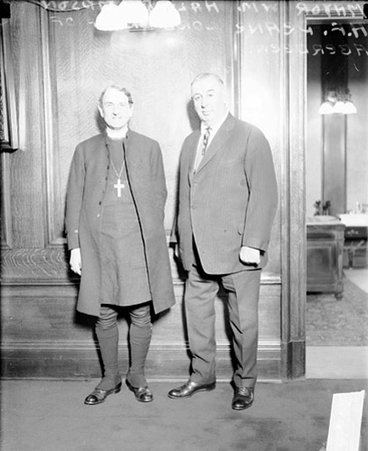 H. F. Deane and William Hale Thompson, looking toward the camera, standing in front of a wall in a room - Chicago Daily News, Inc.