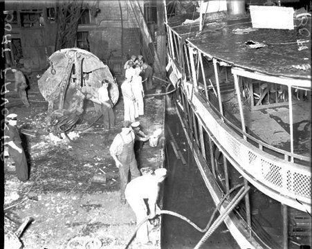 Man standing on a dredging ship, mooring the salvaged steamship Favorite - Chicago Daily News, Inc.