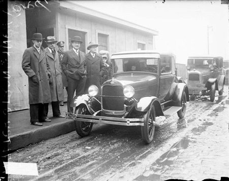 Walter Strong standing with three men and a boy next to a new Ford automobile, light exposure - Chicago Daily News, Inc.