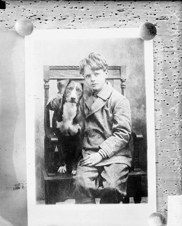 Photograph of Charles A. Lindbergh as a boy, sitting with a dog - Chicago Daily News, Inc.
