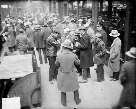 Crowd of unemployed men standing on the sidewalk in front of the Chicago Daily News building, police officer standing nearby - Chicago Daily News, Inc.