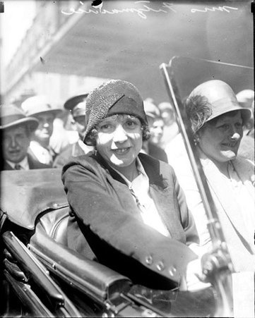 Mrs. James Fitzmaurice and Mrs. Herman Koehl sitting in an automobile on a street in front of a building - Chicago Daily News, Inc.