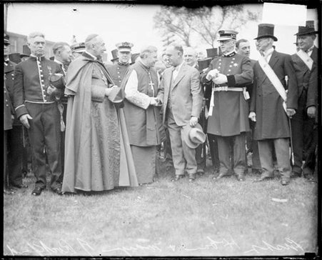 Bishop Hoban shaking hands with the Mayor Rockford, Cardinal Mundelein and other men standing by, light exposure - Chicago Daily News, Inc.
