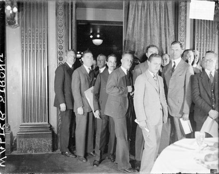 Walter Strong standing with a group of men in front of a doorway in a room - Chicago Daily News, Inc.