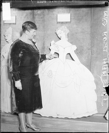 Mrs. Rose Hanskat standing in a room next to cut-out mannequins - Chicago Daily News, Inc.