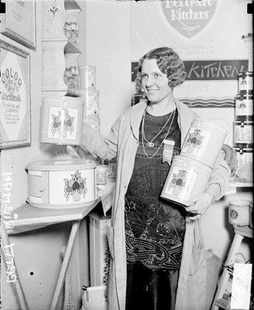 Betty Riemen holding three canisters, standing in a store - Chicago Daily News, Inc.