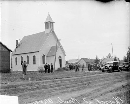 Men wearing suits standing in front of a church in Brule, Wisconsin - Chicago Daily News, Inc.