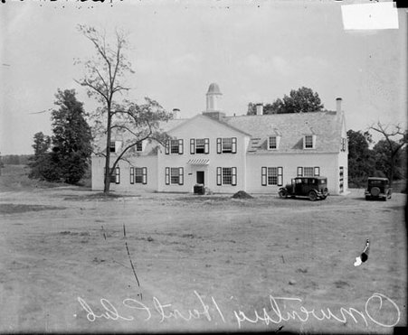 Two-story building at the Onwentsia Hunt Club, two automobiles parked in front of the building - Chicago Daily News, Inc.