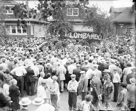 Crowds standing in the street in front of the home of Tony Lombardo during his funeral, dark exposure - Chicago Daily News, Inc.