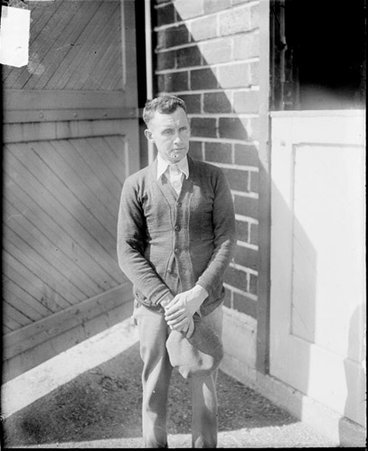 Jimmy Allen standing in front of a stable, dark exposure - Chicago Daily News, Inc.