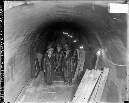 Chicago Avenue water tunnel construction, men standing in an underground tunnel, looking toward the camera - Chicago Daily News, Inc.