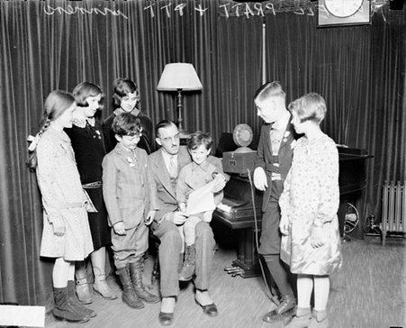 Russell Pratt, WMAQ radio personality sitting with TTT (possibly Topsy Turvy Time) winners - Chicago Daily News, Inc.
