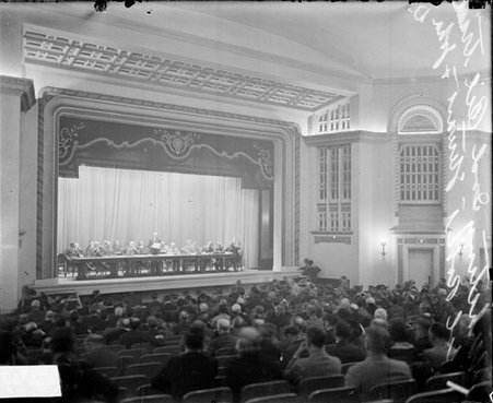 Community Hall in Whiting, Indiana, with group of people sitting at long table on stage - Chicago Daily News, Inc.