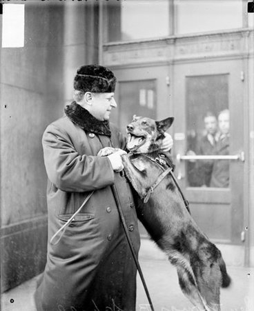 Sen. Thomas D. Schall with dog standing on hind legs - Chicago Daily News, Inc.