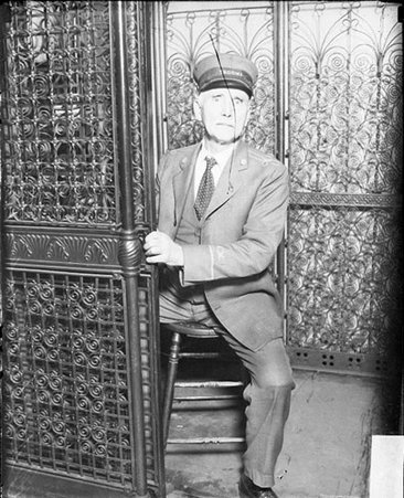 Uniformed man in elevator - Chicago Daily News, Inc.