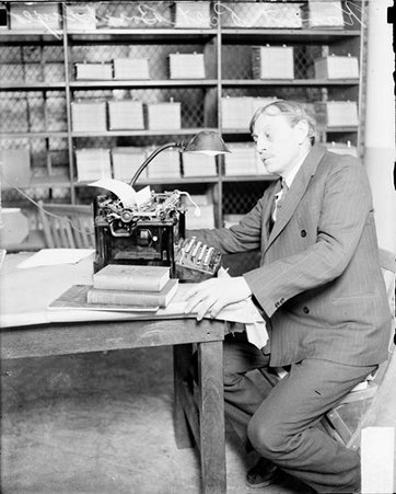 Anton Kvist sitting at table - Chicago Daily News, Inc.