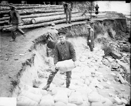 Captain Olson, Evanston, Illinois, Coast Guard Station, holding a sandbag, light exposure - Chicago Daily News, Inc.