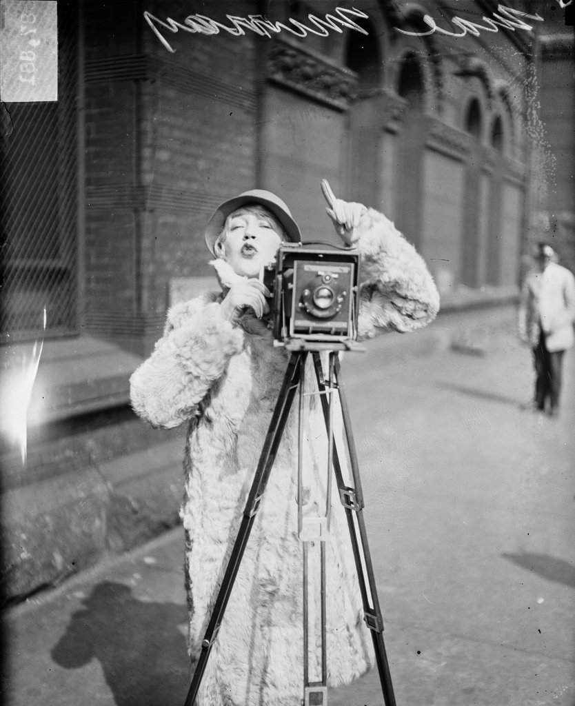 Mae Murray, actress, standing behind camera - Chicago Daily News, Inc.