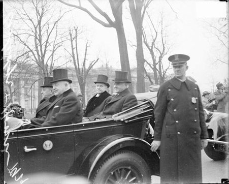 Herbert Hoover and Calvin Coolidge, looking at camera while sitting in auto at the inauguration of Hoover as President of the U.S. - Chicago Daily News, Inc.