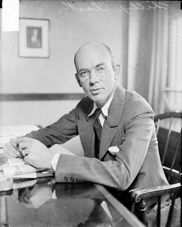 Phillip Clark, sitting a desk facing left - Chicago Daily News, Inc.
