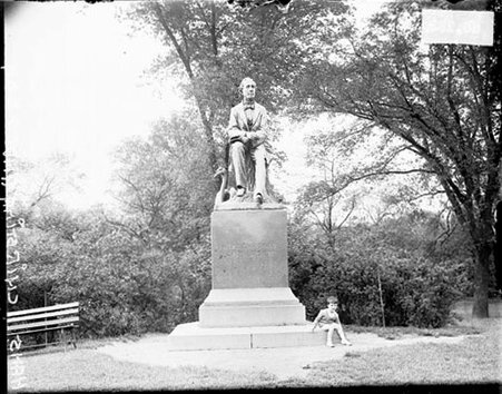 Boy sitting below statue of Hans Christian Anderson in Lincoln Park - Chicago Daily News, Inc.