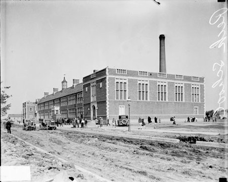 Children standing in front of Peck School as viewed from across a dirt road, dark exposure - Chicago Daily News, Inc.