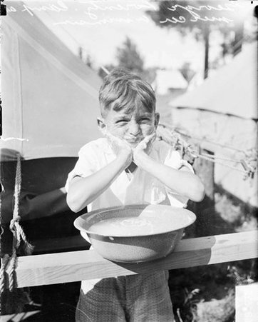 George Lorentz, a boy, squirting water out of his mouth at R.O.T.C. Mercer, Wisconsin, camp - Chicago Daily News, Inc.
