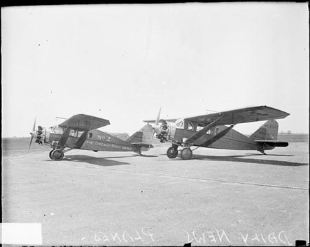 Two Chicago Daily News airplanes sitting on an airfield, viewed at an angle, light exposure - Chicago Daily News, Inc.