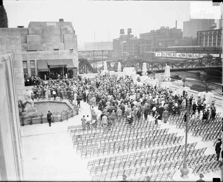 Dedication ceremonies at Daily News plaza for the new Daily News building, crowds are standing in the plaza and a fountain is visible, viewed at an anlgle - Chicago Daily News, Inc.