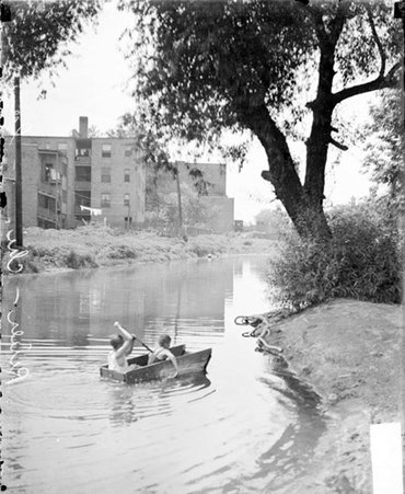 Two boys sailing in a makeshift rowboat on the North branch of Chicago River - Chicago Daily News, Inc.