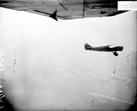 Airplane flying over Chicago, viewed in profile from another airplane, dark exposure - Chicago Daily News, Inc.