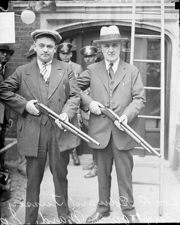 Sergeant Owen Ward and Officer Edward Tussey holding rifles standing in front of a building - Chicago Daily News, Inc.