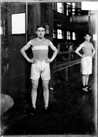 Athlete, E. M. Tourtelout, standing in a gymnasium - Chicago Daily News, Inc.
