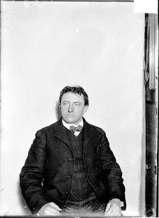Coach, H. Butterworth, looking to his right, sitting against a plain backdrop - Chicago Daily News, Inc.