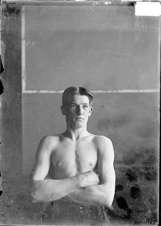 Pugilist, Johnny Kelley, arms folded across his chest, sitting - Chicago Daily News, Inc.