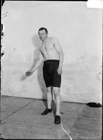 Handball player, Mike Egan, leaning back, right hand in extended, standing on a handball court - Chicago Daily News, Inc.