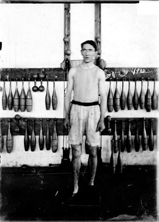 Athlete, Sullivan, University of Chicago, standing in a gymnasium in front of weight training equipment - Chicago Daily News, Inc.
