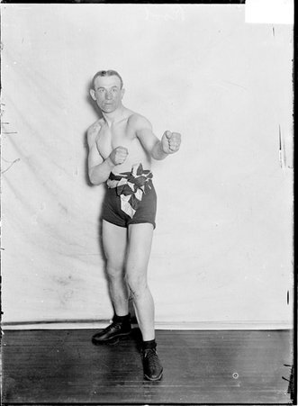 Pugilist, Jack Root, looking right with arms out to right corner, in upright ordinary boxing stance - Chicago Daily News, Inc.